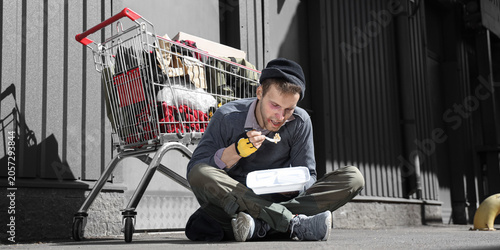 Εκτύπωση καμβά Homeless man eating food on street