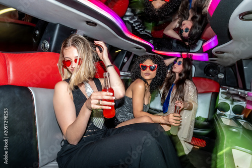 Fotografie Young women celebrating in a limousine at night
