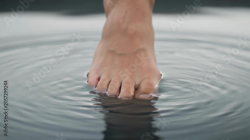 Foot creating ripples in calm water
