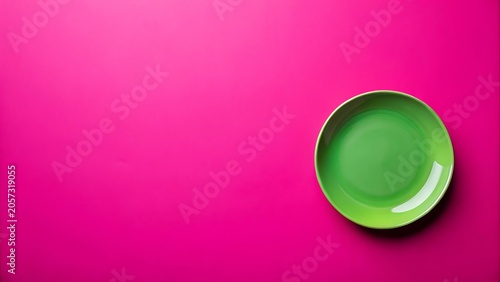 A vibrant green plate rests on a bright pink background, offering a striking contrast and ample space for design elements or textual information.