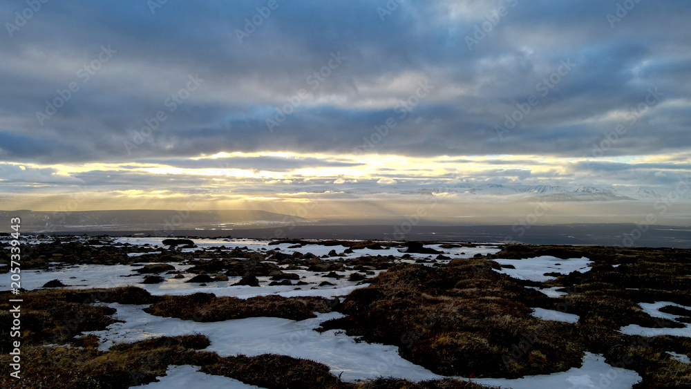 Obraz premium The sun shining through the clouds and illuminating the beautiful Icelandic landscape