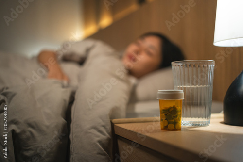 Fotografie Women may take medication before bed to treat illnesses, or take vitamins and supplements for good health and restful sleep