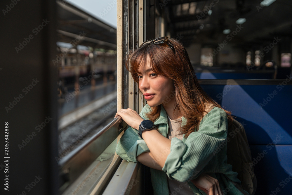 Fototapeta premium Freedom traveler beautiful woman at terminal train station. Happy tourist travel by train on vacation time holiday weekend trip. Female Backpacker arrival at platform railway.