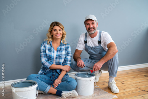 Couple renovating living room together, painting walls, authentic teamwork, 