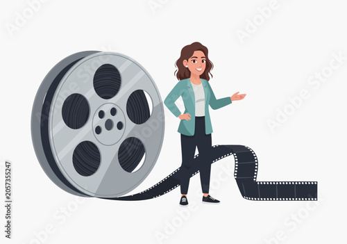 Obraz na plátně Woman presenting film reel and cinematic tape in a stylish outfit standing confi