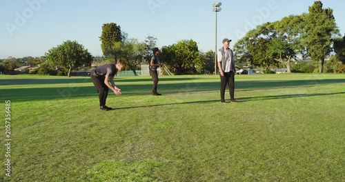 Diverse friends entering cricket field practicing bowling batting and catching using bat, gloves