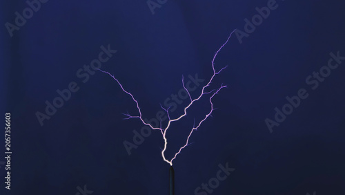 Tesla coil generating high voltage electrical discharge with branching purple sparks