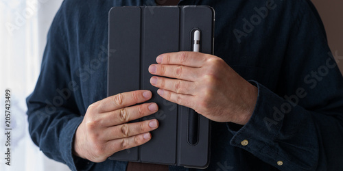 Tablou pe pânză Close up of hands closing a tablet folio cover with stylus for device mockup and