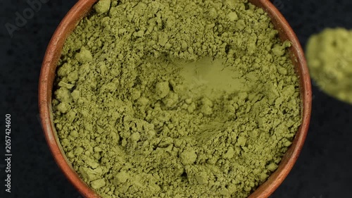 Matcha powder scooping with spoon  from bowl, closeup. Premium matcha green tea powder ingredients