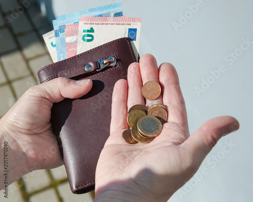 Fotografija Leather purse,  euro banknotes and coins in female hands, selective focus