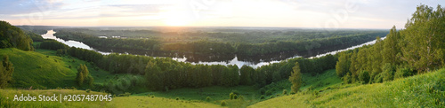 Panorama of a wide winding river flowing through dense forest