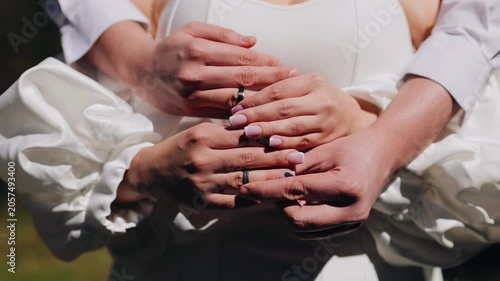 A couple of newlyweds puts on rings hugging. Close-up shooting