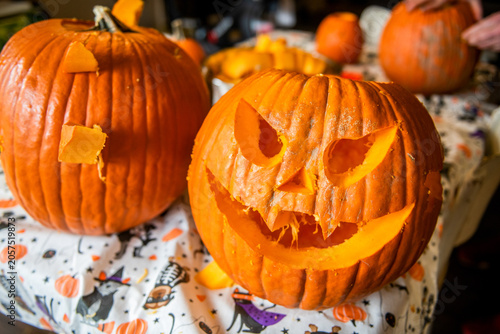 Φωτογραφία Two finished jack o lanterns sit on a Halloween table, one carved with a menacing toothy grin and angled eyes, capturing the spooky payoff of pumpkin carving and classic October tradition