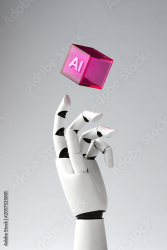 A robotic white hand reaches for a levitating purple transparent cube with 