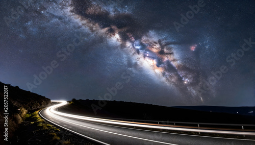Milky Way Over Desert Road: A long exposure captures the ethereal glow of the Milky Way galaxy stretching across the night sky.