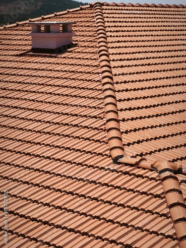 High-Angle View of Red Clay Roof Tiles with Chimney Detail on a Modern House