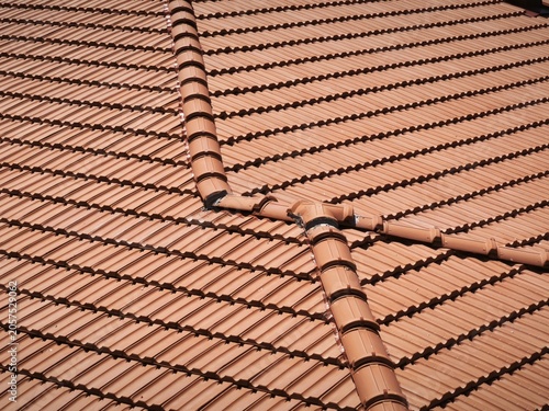 High-Angle View of Red Clay Roof Tiles with Chimney Detail on a Modern House