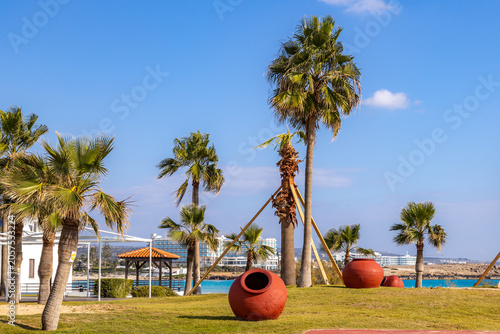Quadro su tela Decorative clay amphora pots on green grass lawn of resort park near sea