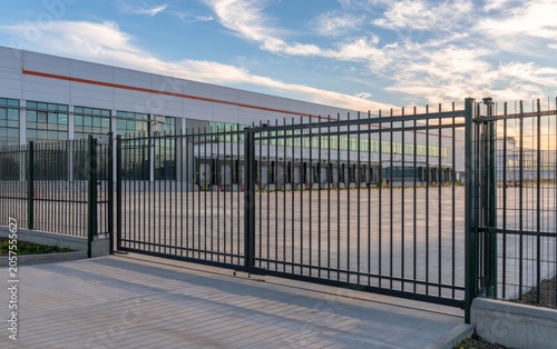 Secure Logistics Facility Perimeter With Modern Fencing and Spacious Loading Area At Sunset