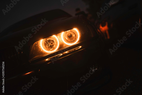 Canvastavla Bmw car headlight glowing orange in darkness