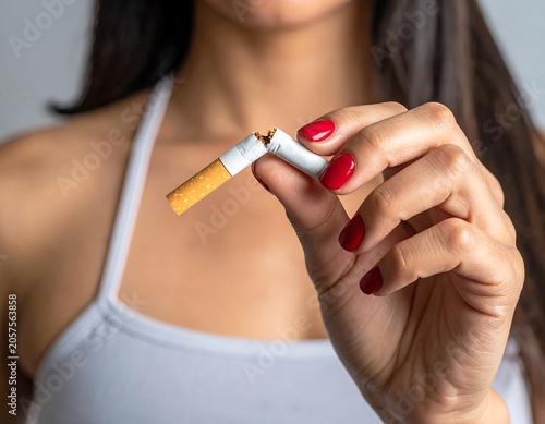 Determined Young Woman Breaking Cigarette by Hand in Indoor Closeup