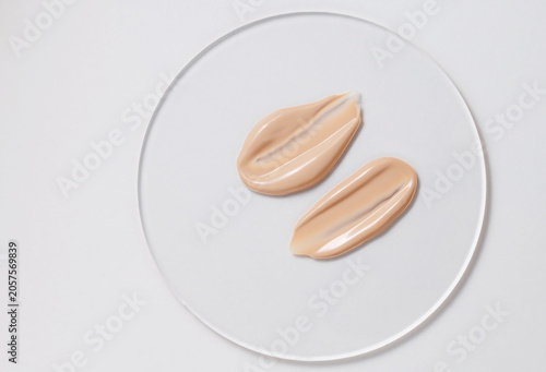Close-up of two beige foundation samples on a white background.