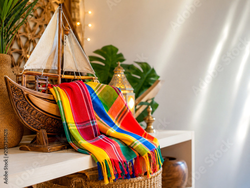 Kikoy cloth draped over carved dhow model on retail shelf with patterns