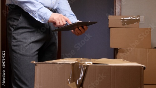 Foto Deliveryman using a digital tablet to manage incoming packages and update logist