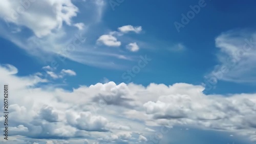 Time-lapse video of majestic cumulus clouds morphing across a pristine deep blue sky, brilliant high-key sunlight, slow push-in wide video with a low horizon line, concept of serene natural beauty