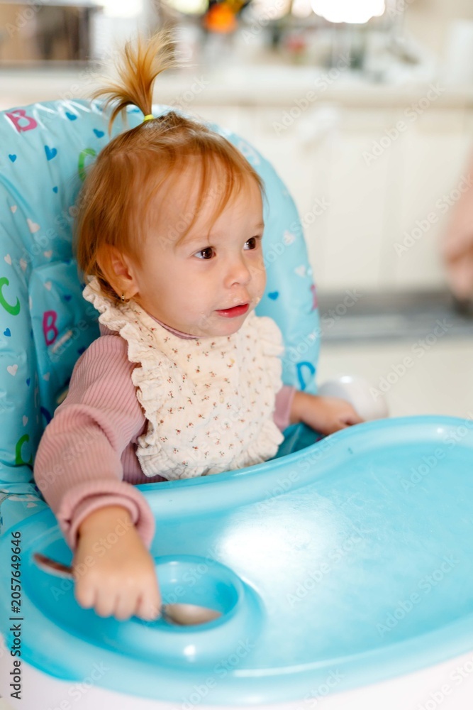 Fototapeta premium Toddler girl learning self feeding