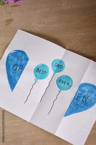 Top view of a Father's Day greeting card with the message “Best Dad Ever” placed on a clean background. Minimal holiday composition celebrating fatherhood and family appreciation.