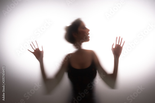 Woman trapped in frosted glass space seeking for an escape