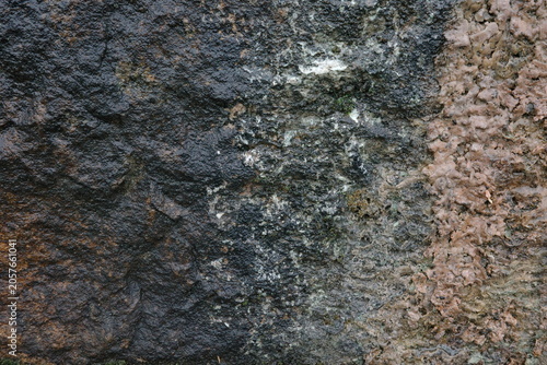 Close-up of a weathered stone and concrete surface featuring rough textures, natural color variations, and aged details. Ideal abstract background for design, architecture, and industrial themes.