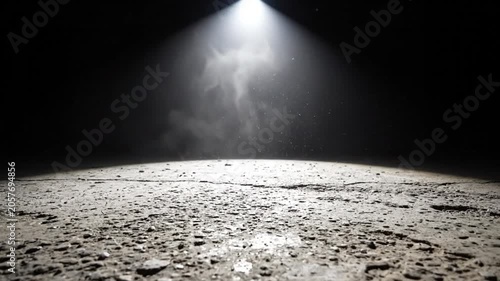Dramatic Spotlight Shining Down on Textured Ground in a Dark Abstract Setting with Particles and Mist
