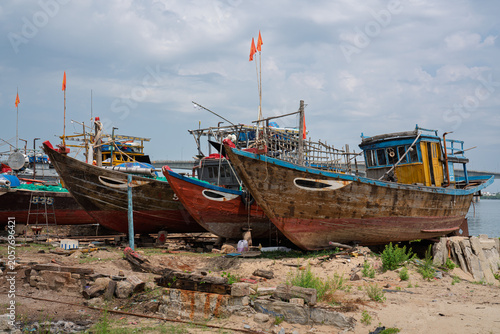 Vászonkép Weathered wooden fishing boats hauled ashore for maintenance and repair along the central coast of Vietnam