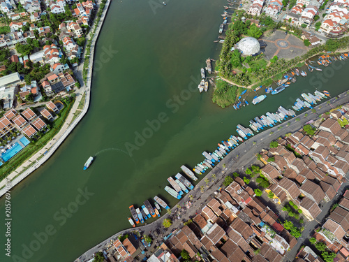 Dense pattern of traditional rooftops and riverside moorings captured from above in Hoi An.