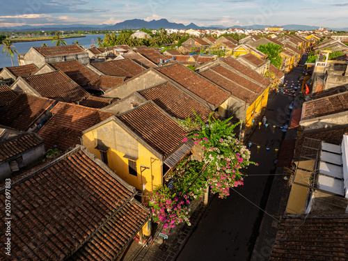 Flowering bougainvillea decorates a narrow street among traditional houses in Hoi An.