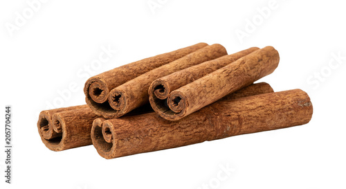 Fotografía A pile of whole cinnamon sticks with a rough textured bark, isolated on white