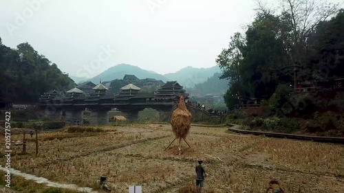 Traditional wooden village and covered bridge in misty rural mountain valley