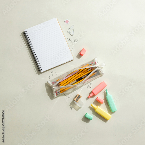 Notebook and pencil case are arranged on a clean surface alongside various stationery items for study preparation.