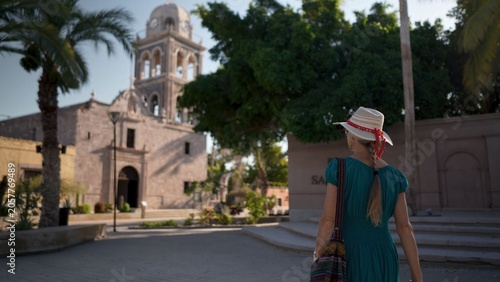 Foto Happy woman explores the Loreto Mission church in Loreto, Baja California Sur at sunrise