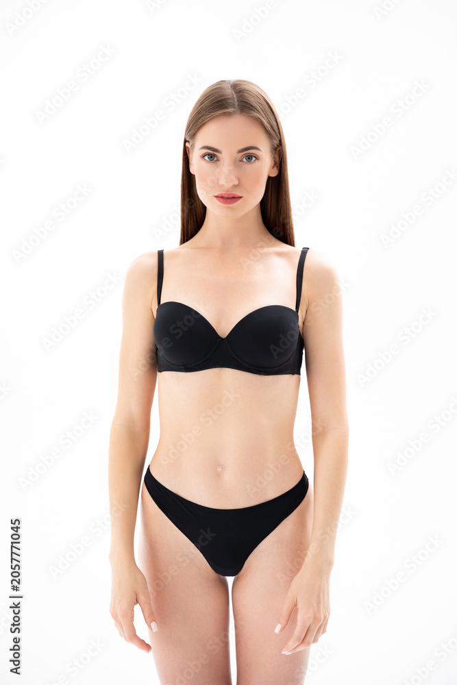 Obraz premium Beautiful girl in black lingerie posing on a white Isolated background
