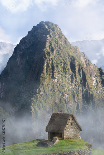 The guard's house at the entrance to Machu Picchu, with Huayna Picchu mountain in the background.
