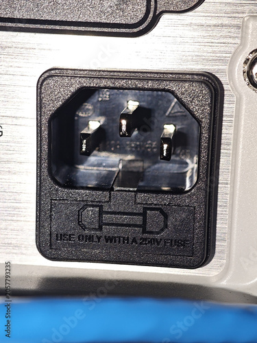 Computer power inlet connector with fuse holder on metal panel, close up