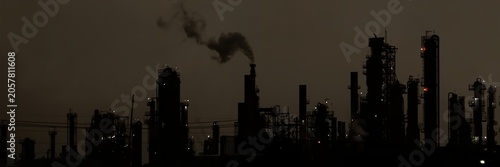 Vászonkép Silhouette of an industrial plant with smoke against a dark sky.