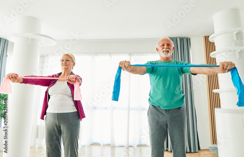 Photos Senior couple exercise stretching and exercising with resistance band at home, h