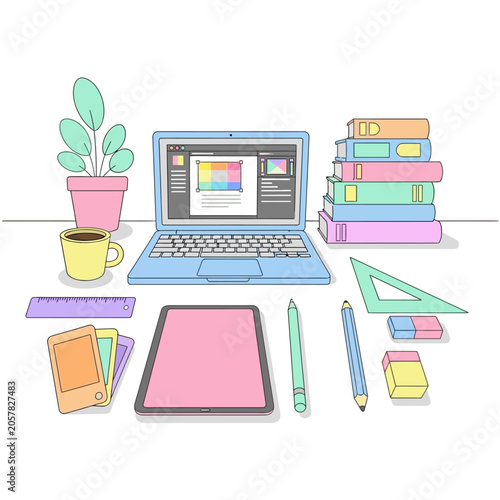 Colorful workspace with laptop tablet and stationery.