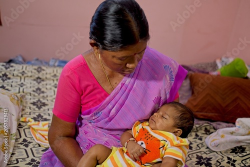 Mother holds her sleeping baby in domestic setting