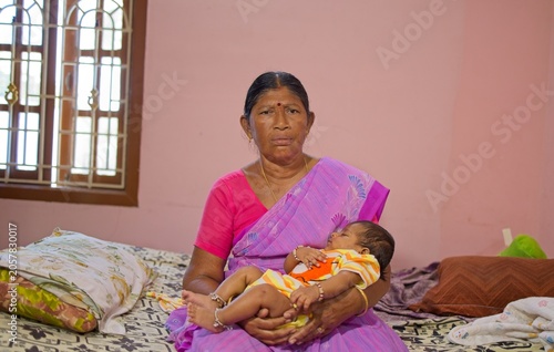 Woman holding baby in colorful room during daytime in India