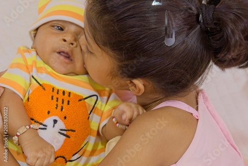 Sweet interaction between sibling children at home during a sunny afternoon